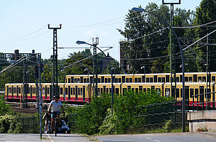 Neue S-Bahn Zwei S-Bahnen der Baureihe 483/484, im Vordergrund unscharf Radfahrer und Autoverkehr