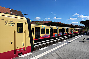 Neue S-Bahn Baureihe 483/484 mit 100-Jahre-Jubiläumsschriftzug am Gleis mit Sonderzug zur Auslieferung des letzten 106. neuen S-Bahnzugs