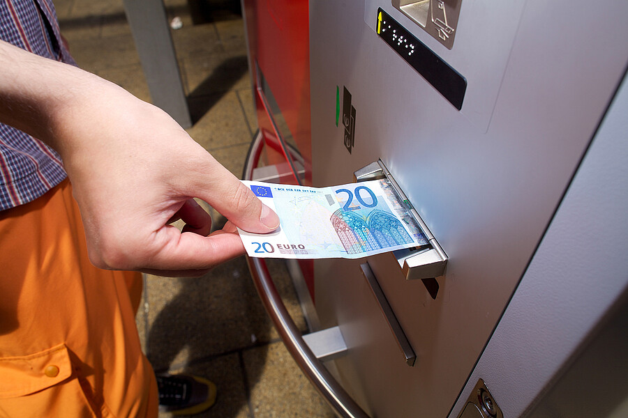 S Fahrgast bezahlt mit Geldschein am Fahrkartenautomat