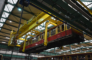 A pre-redesign series 481 train suspended from the Schöneweide workshop crane.