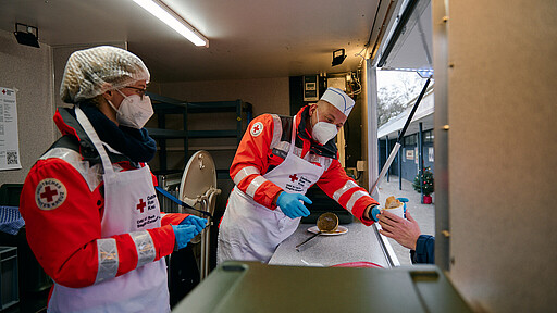 Aus dem Hänger in den Magen Clara Schwehm (l.) und Dieter Westphal vom Team des DRK-Kreisverbands Berlin Steglitz-Zehlendorf e.V. verteilen warme Mahlzeiten und Getränke.
