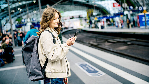 ine Reisende informiert sich mit dem Smartphone auf dem Bahnsteig im Berliner Hauptbahnhof.