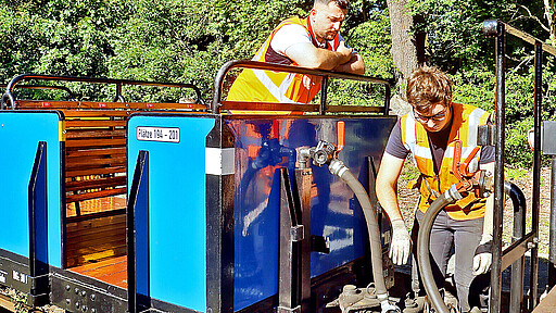 Azubi Mahmood Rashid (l.) und Parkeisenbahn-Kollege Elias Ellermann kuppeln die beiden Wagen aneinander.