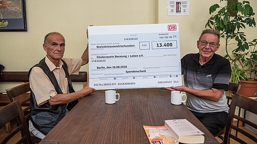 Besucher der Tagesstätte von Zelterpate mit Spendenscheck