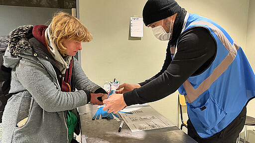 Yvonne trägt sich bei der Notübernachtung in die Anmeldeliste ein.