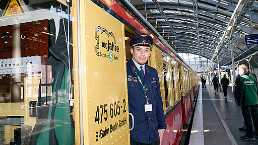 Vor der Abfahrt am Ostbahnhof Ein Mitglied des Vereins Historische S-Bahn steht in Uniform in der Tür des Sonderzugs.