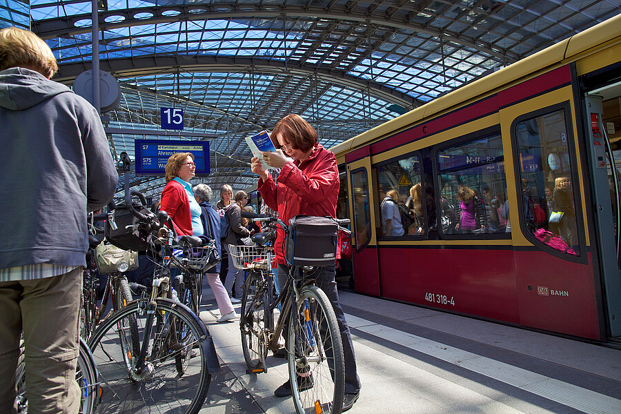 Fahrgäste mit Fahrrädern warten auf dem Hauptbahnhof auf einfahrende S-Bahn