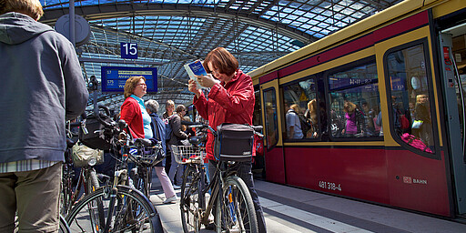 Fahrgäste mit Fahrrädern warten auf dem Hauptbahnhof auf einfahrende S-Bahn