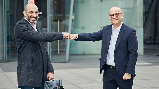 Martin Seiler, Vorstand Personal und Recht der DB AG, begrüßt Wael Al-Iman als den 22.000 Mitarbeiter der im Jahr 2021 bei der DB AG angestellt wurde.