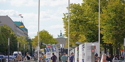 Unter den Linden Blick von Unter den Linden auf das Brandenburger Tor. In der Mitte der Straße zieht sich ein Weg für Fußgänger, der von Linden eingerahmt wird.