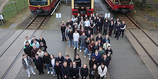 Die neuen Azubis der S-Bahn Berlin vor den derzeit aktiven Baureihen auf dem Gelände des Werks Schöneweide