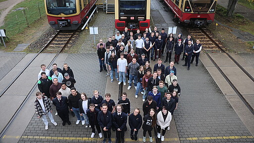 Die neuen Azubis der S-Bahn Berlin vor den derzeit aktiven Baureihen auf dem Gelände des Werks Schöneweide