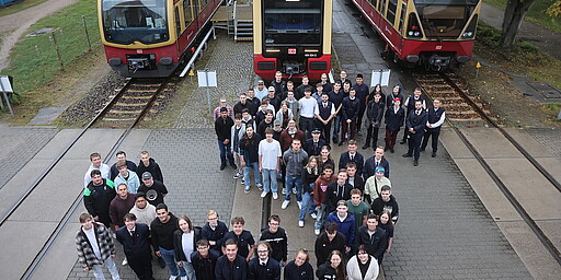 Die neuen Azubis der S-Bahn Berlin vor den derzeit aktiven Baureihen auf dem Gelände des Werks Schöneweide