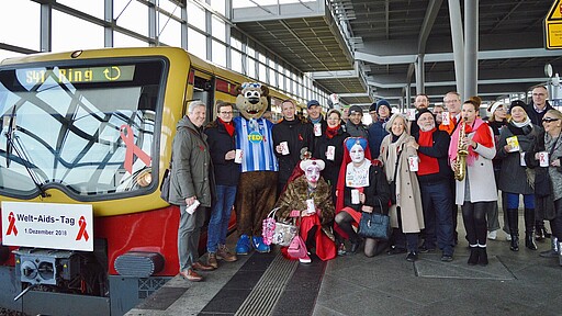Welt-Aids-Tag 2018 Das Team der Spendenaktion am 1. Dezember 2018 neben dem geschmückten Zug.