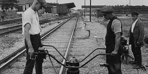 Schieneneinbau Zwei Männer bauen eine Stromschiene ein, ca. 1928