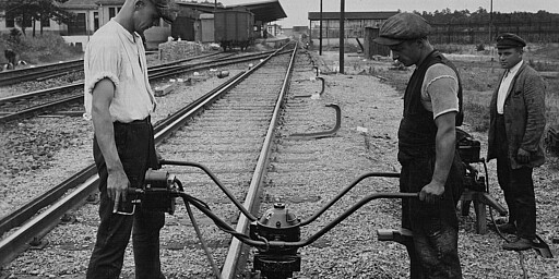 Schieneneinbau Zwei Männer bauen eine Stromschiene ein, ca. 1928