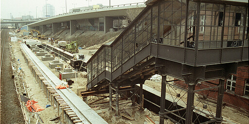 Heidelberger Platz Am 25. September 1989 beginnen die Bauarbeiten zur Reaktivierung des Südrings unter der Regie des Berliner Senats. 585 Millionen Mark werden dafür veranschlagt. In zwei Bauabschnitten soll die Bahnstrecke von Westend bis Schöneberg bis 1992 und weiter bis zur Sonnenallee 1994 wieder hergestellt werden. Der Mauerfall und die politische Wende ändern diese Pläne: Von Neukölln soll danach nicht die Strecke zum Bahnhof Sonnenallee, sondern die Gleise nach Köllnische Heide und weiter zum Baumschulenweg und damit der Anschluss zum Netz der S-Bahn in Ostberlin wiederhergestellt werden. Am 17. Dezember 1993 wird der 18,4 Kilometer lange Südring zwischen Westend und Baumschulenweg wieder eröffnet. Baukosten insgesamt: 775 Millionen Mark. 14 Bahnhöfe sind von Grund auf neu gebaut worden, wie hier am Heidelberger Platz.