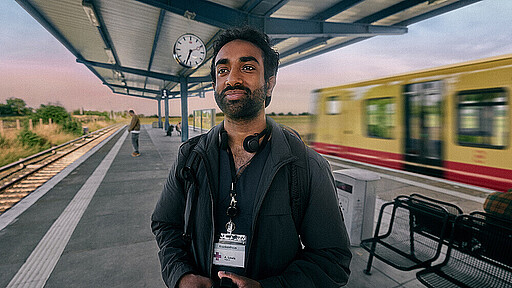 Job in Mitte. Zuhause in Brandenburg. Ein Mann steht mit Kaffeebecher am Bahnhof und warte auf die S-Bahn, um zur Arbeit zu fahren.
