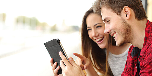Couple sharing media content from a tablet Our digital services keep you up to date when you’re on the go