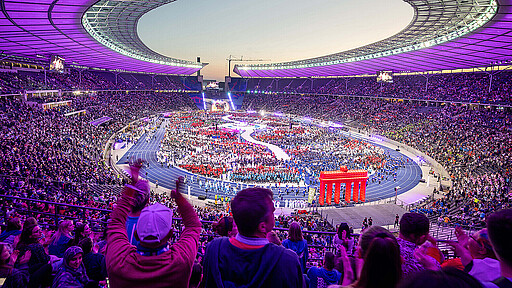 Blick auf die Eröffnungsfeier der Special Olympics World Games in ein in Lila getauchtes Olympiastadion