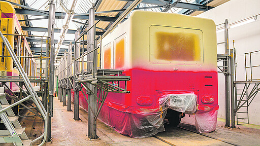 Langlebigkeit Lackiererei - Farblack Erst rot dann gelb - in der Lackierkabine wird der Zug von Hand besprüht