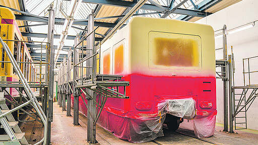 Erst rot dann gelb - in der Lackierkabine wird der Zug von Hand besprüht Erst rot dann gelb - in der Lackierkabine wird der Zug von Hand besprüht
