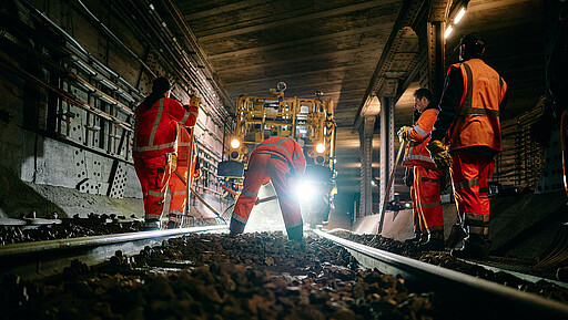 Mit Schottergabeln stopfen die Gleisbauer: innen die Löcher, die die Maschine vor ihnen hinterlassen hat.