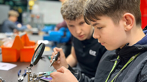 Löten lernen Erik lernt von Azubi David Wendorf den Umgang mit dem Lötkolben.