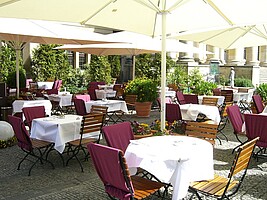 Restaurant Refugium mit Tischen und Sitzen unter Sonnenschirmen