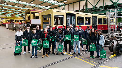 Der Neuzugang im Team S-Bahn stellt sich vor Gruppenfoto der 18 jungen Menschen, die am 3. März eine Ausbildung zum:zur Industrieelektriker:in mit elfmonatiger Zusatzausbildung zum:zur Triebfahrzeugführer: in (Tf) bei der S-Bahn Berlin im Werk Schöneweide begonnen haben.