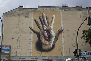 Ein Bild von zwei sich überlappenden Händen an einer Wand