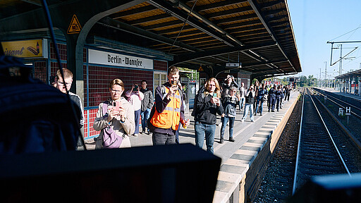 Fotostopp am Wannsee Der Sonderzug der Baureihe 481 erreicht den S-Bahnhof Wannsee, wo zahlreiche Fotobegeisterte und winkende Fahrgäste ihn am Bahnsteig empfangen und Erinnerungen an Jahrzehnte Berliner S-Bahn-Geschichte festhalten.