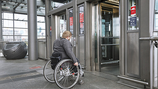 Reisender im Rollstuhl nutzt einen Aufzug auf einem barrierefreien Bahnhofsgleis (Berlin Südkreuz)