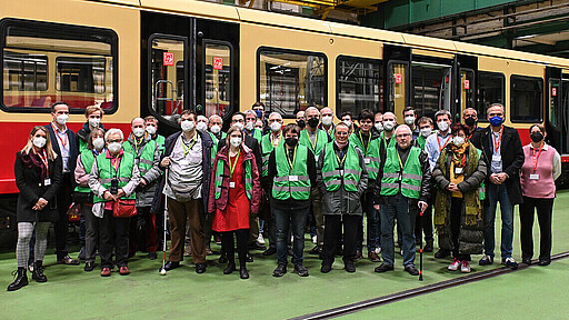 Runderneuerung vor und auf der Schiene Alte und neue Beiratsmitglieder posieren zum Gruppenfoto vor einer runderneuerten S-Bahn der Baureihe 481