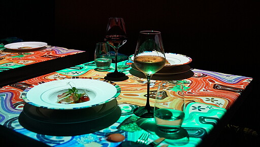 8 außergewöhnliche Restaurants in Berlin Tisch mit Gericht und Weinglas
