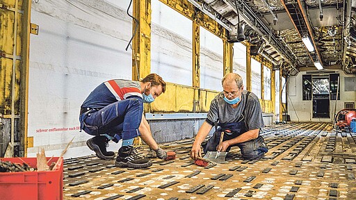 200 Klebepunkte müssen entfernt werden Paul Weese und Uwe Heinze beim Abschluss der Fußboden-Demontage, bevor der Wagenkasten an die nächste Bearbeitungsstation übergeben wird.