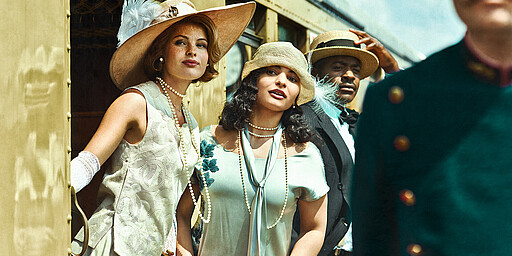 Die große Elektrisierung Zwei Damen steigen in den 20er Jahren aus dem Zug und schauen sich erwartungsvoll um.