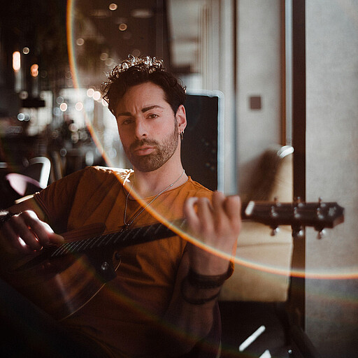 Sänger Nico David Der Sänger Nico David hält seine Gitarre in den Händen