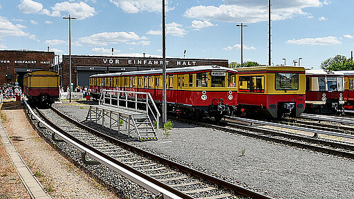 Der Blick aus einem historischen Zugwagon auf das Werkgelände in Erkner verbindet die Atmosphäre vergangener S-Bahn-Jahrzehnte mit dem Ort ihrer Bewahrung.