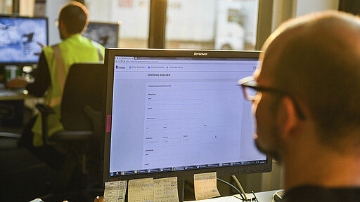 Mann sitzt im Büro vor einem Monitor Mann sitzt im Büro vor einem Monitor