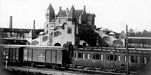 Westhafen Blick von Süden auf den Bahnhof Putlitzstraße um 1900. Im Vordergrund ist ein vor 1900 gebauter Abteilwagen zu sehen. Hinter den Wagen liegt der Bahnsteig für die Vorortzüge der Hamburger und Lehrter Bahn. Dahinter ist das mächtige Empfangsgebäude mit dem rechts davon liegenden Ringbahnsteig zu sehen. Links ist der 1897 erbaute hölzerne Putlitzsteg zu erkennen, der erst 1911 durch den Bau der mächtigen Putlitzbrücke ersetzt wird.