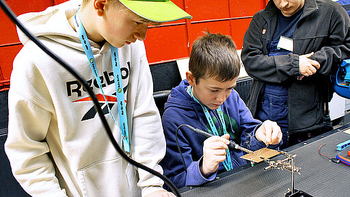 Tüfteln und Löten Cody (Mitte) lötet konzentriert – er interessiert sich für den Beruf des Industrieelektrikers.