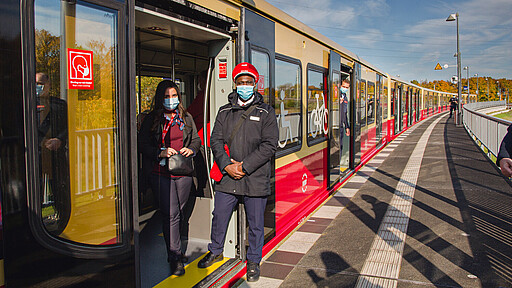 Zwischenhalt am neuen S-Bahnhof Waßmannsdorf Der Sonderzug zum BER, eine runderneuerte S-Bahn der Baureihe 481, beim Zwischenhalt am neuen S-Bahnhof Waßmannsdorf. Unter den Fahrgästen auch zwei Auszubildende von DB Station&Service: Jalin Ulusev (links) und Kevin Kamara.