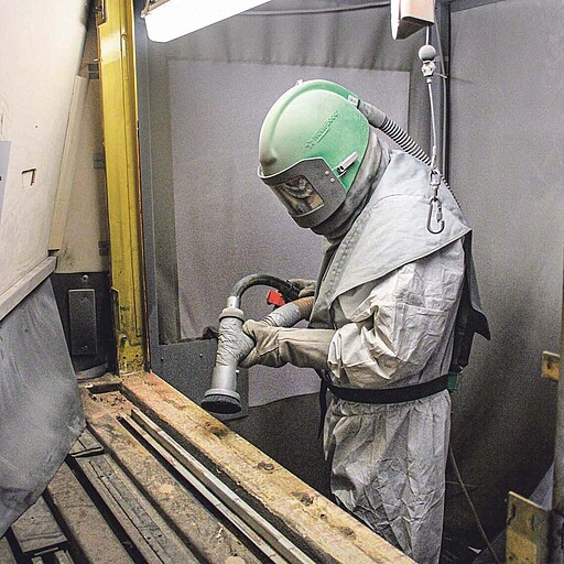 Dirk Voß beim Sandstrahlen Mit dem Sandstrahlverfahren wird dem Rost zu Leibe gerückt.