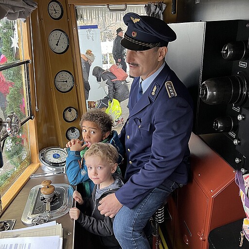 Bela (hinten) und Standley dürfen bei Lokführer Walied Schön im Führerstand mitfahren.