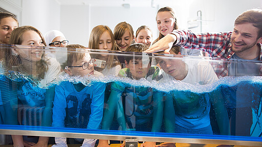 Besuch im Science Center Spectrum Spielerisch erschließen sich grundlegende naturwissenschaftliche Zusammenhänge: Die Wellenwippe zeigt, wie Wellen in Flüssigkeiten entstehen.
