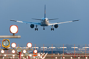 Ein Lufthansa-Airbus landet in Tegel. In der einsetzenden Dämmerung ist die Befeuerung bereits eingeschaltet. Sie unterstützt die Piloten bei der exakten Landung.