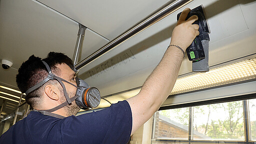 Instandhalter Christopher R. beseitigt Graffiti im Fahrgastraum.