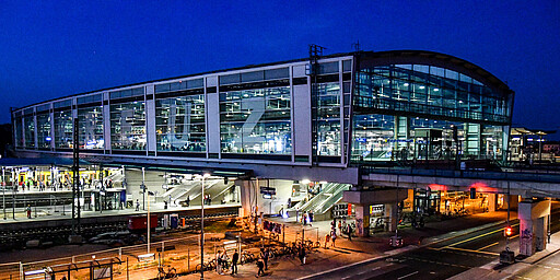 Ostkreuz Die Ringbahnhalle am Ostkreuz zur Blauen Stunde am 20. April 2018. Seit dem 6. Oktober 2017 prangt der Bahnhofsname, im Mittel 6,50 Meter hoch, über die ganze Länge der westlichen Glasfassade der Ringbahnhalle. Die Folien-Farbe heißt „904 Silbersee metallic“.