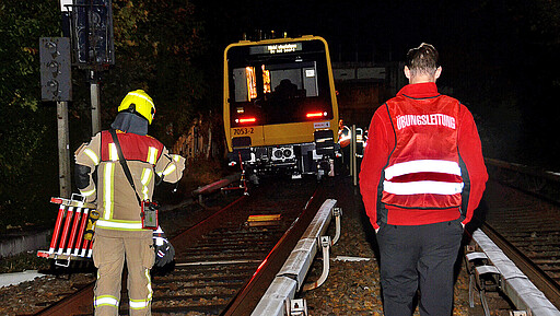 Kräfte der Feuerwehr machen sich auf den Weg zu den stillstehenden Zügen, um zu überprüfen, ob es einen Personenunfall gegeben hat.